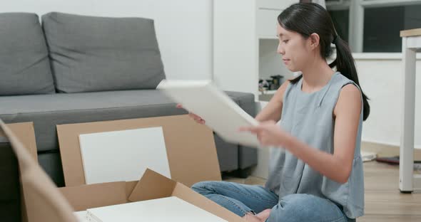 Woman assembling furniture at home