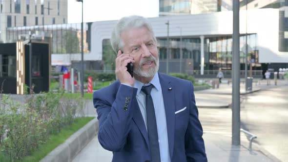 Walking Old Businessman Talking on Phone