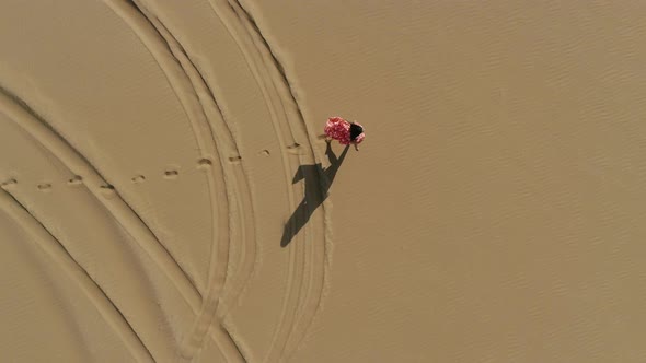 Aerial view of attractive woman walking at a desert landscape, U.A.E.