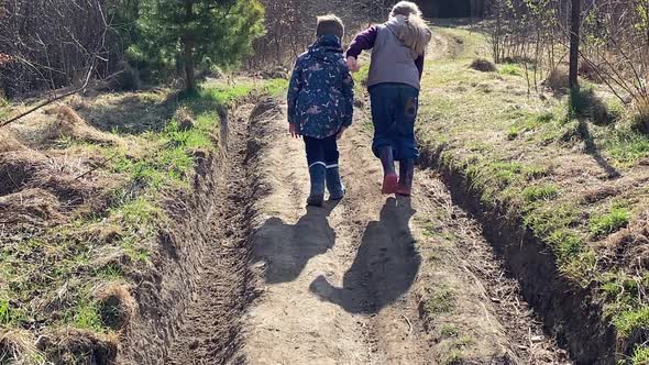 Two Kids Boy and Girl Travel Mountain Road Climbing to Top of Hill