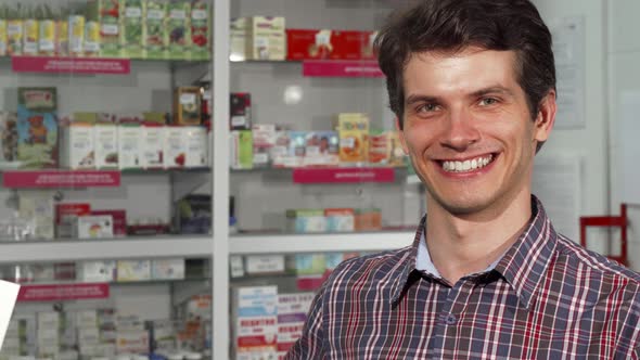 Happy Handsome Man Smiling Holding Shopping Bag at the Pharmacy