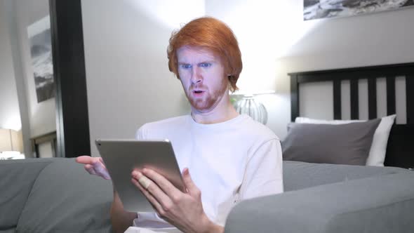 Angry Yelling Redhead Man Using Tablet in Bedroom