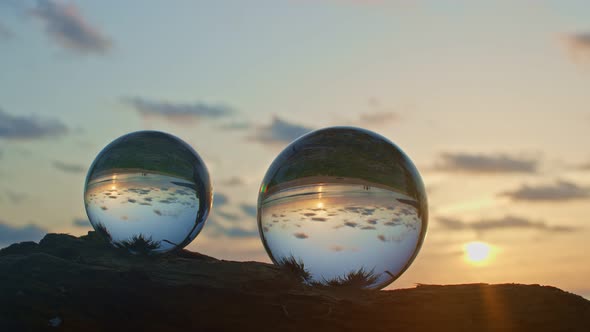 Two Crystal Balls On A Timber At Sunset