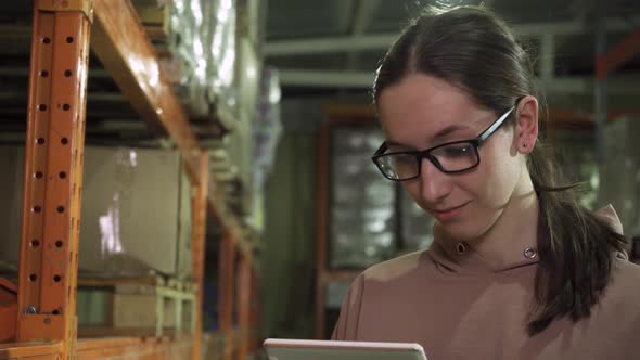 Closeup of a Young Employee with a Computer Tablet Working in the Warehouse