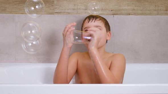 Boy Playing in Bathroom Child Bathe and Inflates Soap Bubbles