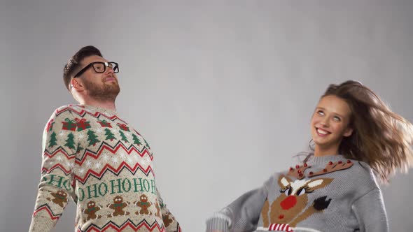 Happy Couple in Christmas Ugly Sweaters Dancing 26