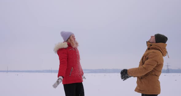 Young Couple Throwing Snow in Slow Motion