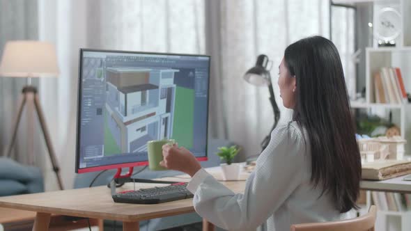 Asian Woman Engineer Drinking Coffee While Designing House On A Desktop At Home