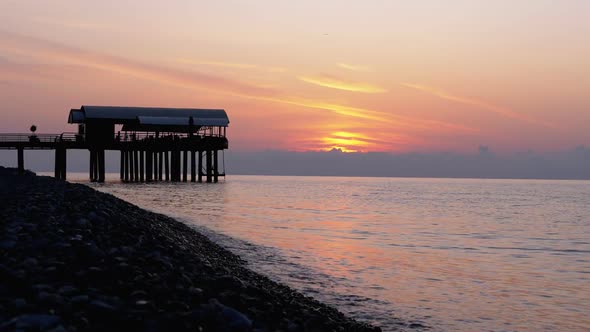 Panorama of the Sunset Over the Sea Next To the Silhouette of the Pier.