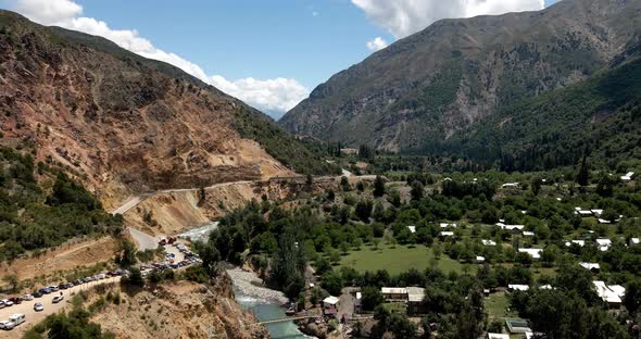 Aerial view backwards of the Maule river in the central zone with arid mountains in Chile on a sunny