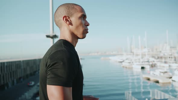 Bald concentrated sportsman wearing black t-shirt walking outdoors