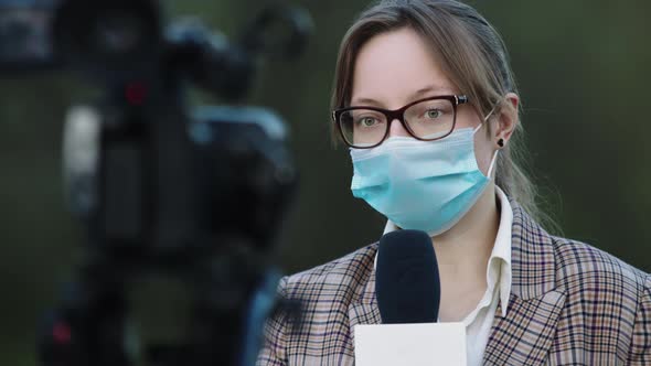 Breaking News, During Coronavirus Pandemic. Female Reporter with Medical Mask Speaking Into