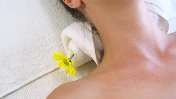 Relaxed Young Woman Lying on Spa Bed for Massage