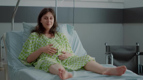 Portrait of Pregnant Caucasian Woman Sitting in Hospital Ward