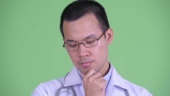 Face of Stressed Asian Man Doctor with Eyeglasses Thinking and Looking Down