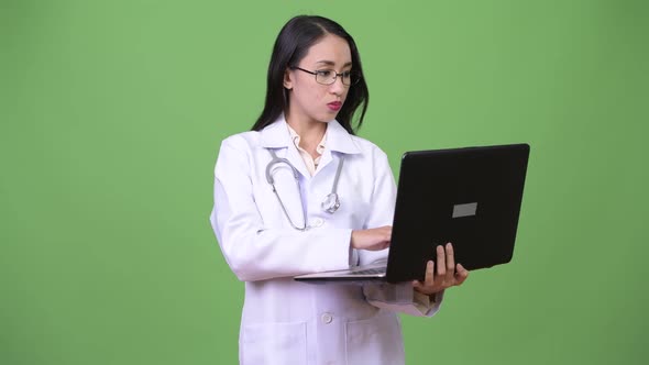 Young Beautiful Asian Woman Doctor Using Laptop