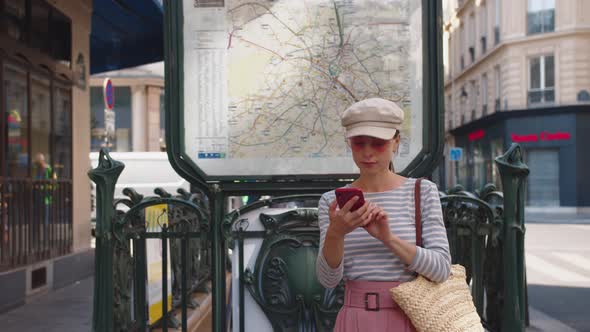 A young girl with a phone at the metro station