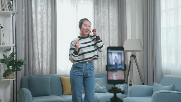 Asian Woman Dancing While Shooting Video Content For Social Networks With A Smartphone Camera