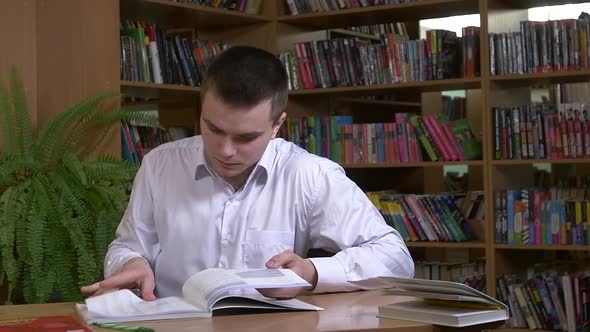 Male Student Researching with a Book in a Library, Slow Motion