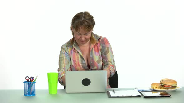 Female Office Worker with Fast Food on Desktop