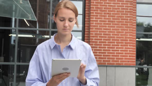 Casual Woman Walking and Using Tablet Browsing Online