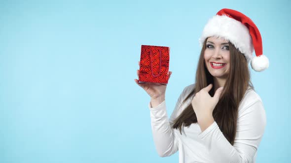 Happy Girl in Santa Hat Holds Gift Bag. Christmas
