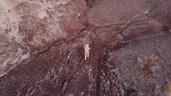 the Astronaut Walks Carefully Along the Rock