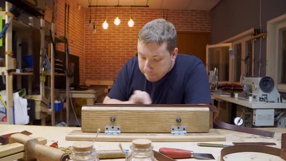 Working Process of Making Brown Leather Belt in the Leather Workshop. Man's Hands Creating New