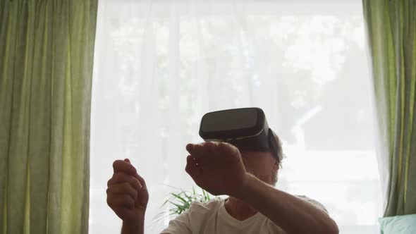 Senior man in social distancing using VR headset