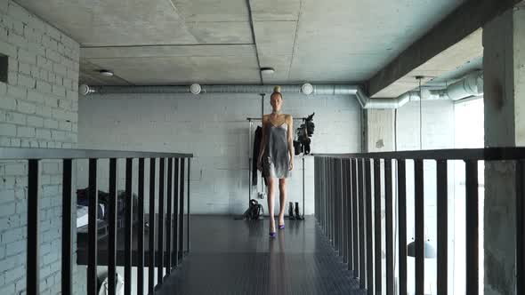 Female Model Walks Along Dark Catwalk in Her Shoes at Home and Shows an Outfit