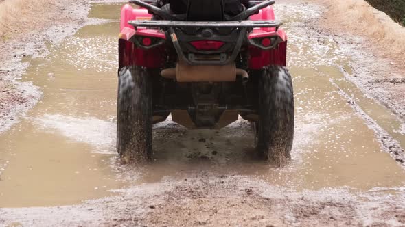 People Driving All-Terrain Vehicles through Mud