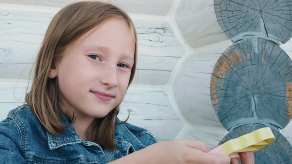 A Girl in Denim Clothes with a Sweet Smile and Loose Hair with a Gentle Look is Holding a Popit Toy