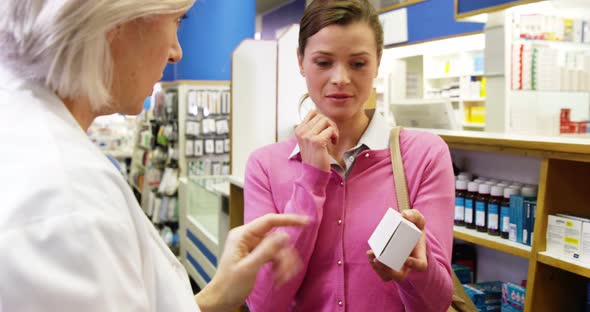 Pharmacist assisting the bottle of drug to customer