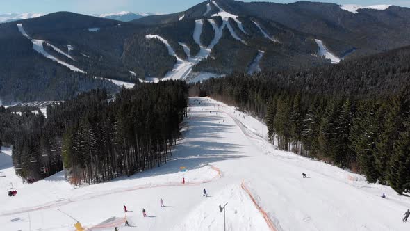 Aerial View Crowd of Skiers Skiing on Peak Ski Slope Near Ski Lifts. Ski Resort