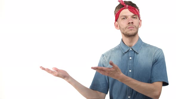 Handsome Hipster Guy with Beard Wearing Bandana and Denim Shirt Introducing Product Demonstrating