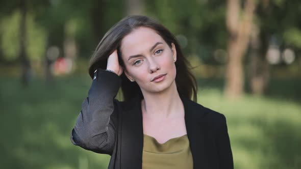 Portrait of a Young Business Girl in a Jacket in the Park