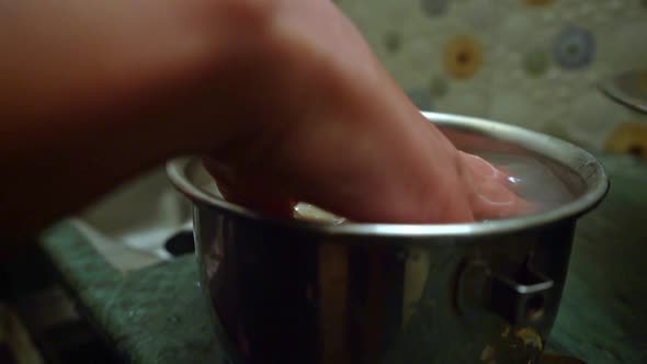 Hand Washing Rice Grains In A Pot Before Cooking At The Kitchen