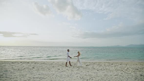 Happy Couple Running on Tropical Beach at Sunset Vacation  Slow Motion