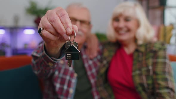 Happy Senior Family Couple Grandparents Man Woman Looking at Camera Demonstrating Keys From New Flat