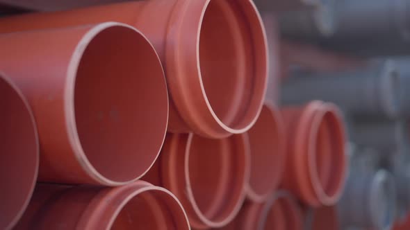 Closeup Orange Plastic Pipes Stack at Warehouse