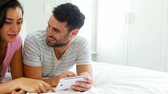 Couple interacting with each other while using digital tablet in the bedroom