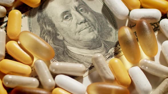 Medical Pills Lying on US Dollar Bill Move Over