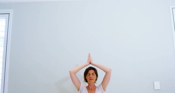 Woman practicing yoga in bedroom