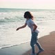 A Young Woman Throwing Stones Into the Sea Waves - VideoHive Item for Sale
