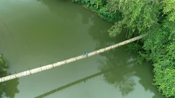 Villagers Walking On A Suspension Bridge