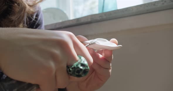 Woman Making Doll Ceramic Part Close Up. Female Sitting and Creating Ear for Doll at Home at Table