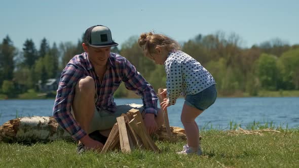 Family is Resting on the Bank of the River with a Tent