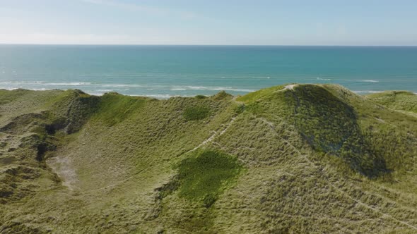 An aerial view from behind the sanddune can be seen of the beach and the North Sea.