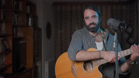 Manly Musician Approaching to the Camera Smiling to Play the Guitar