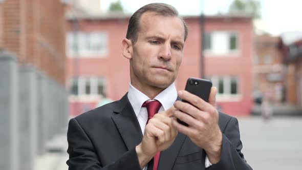 Portrait of Businessman Busy Using Smartphone